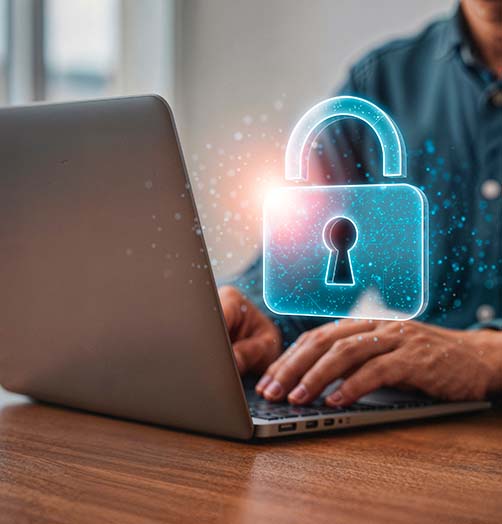 Professional working on a laptop with holographic security lock representing technical document protection enforcement